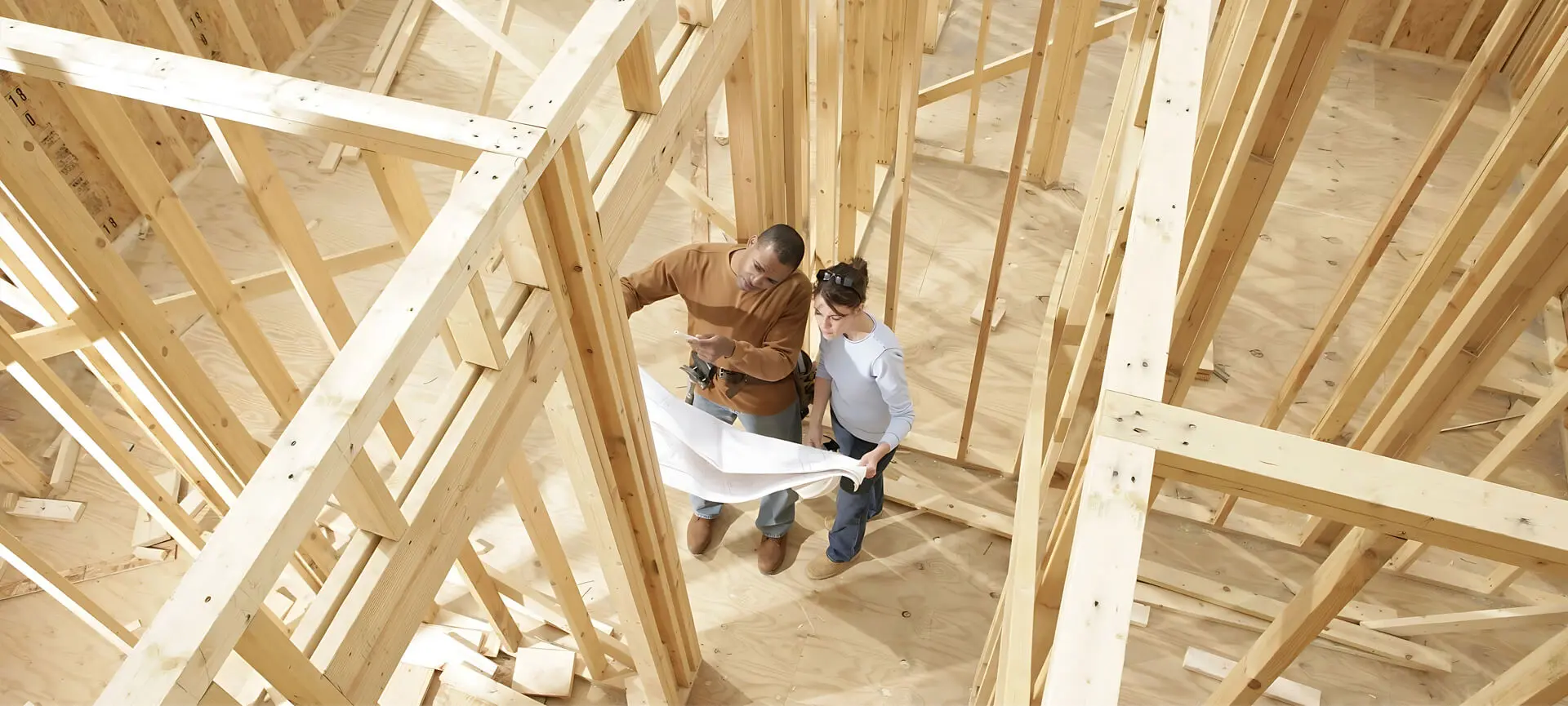 Two men looking at a building plan in the construction process.